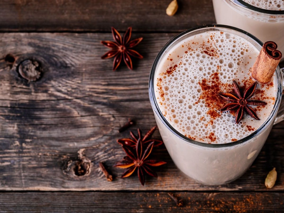 Eine Tasse mit Apfel-Chai-Latte auf einem Holztisch.