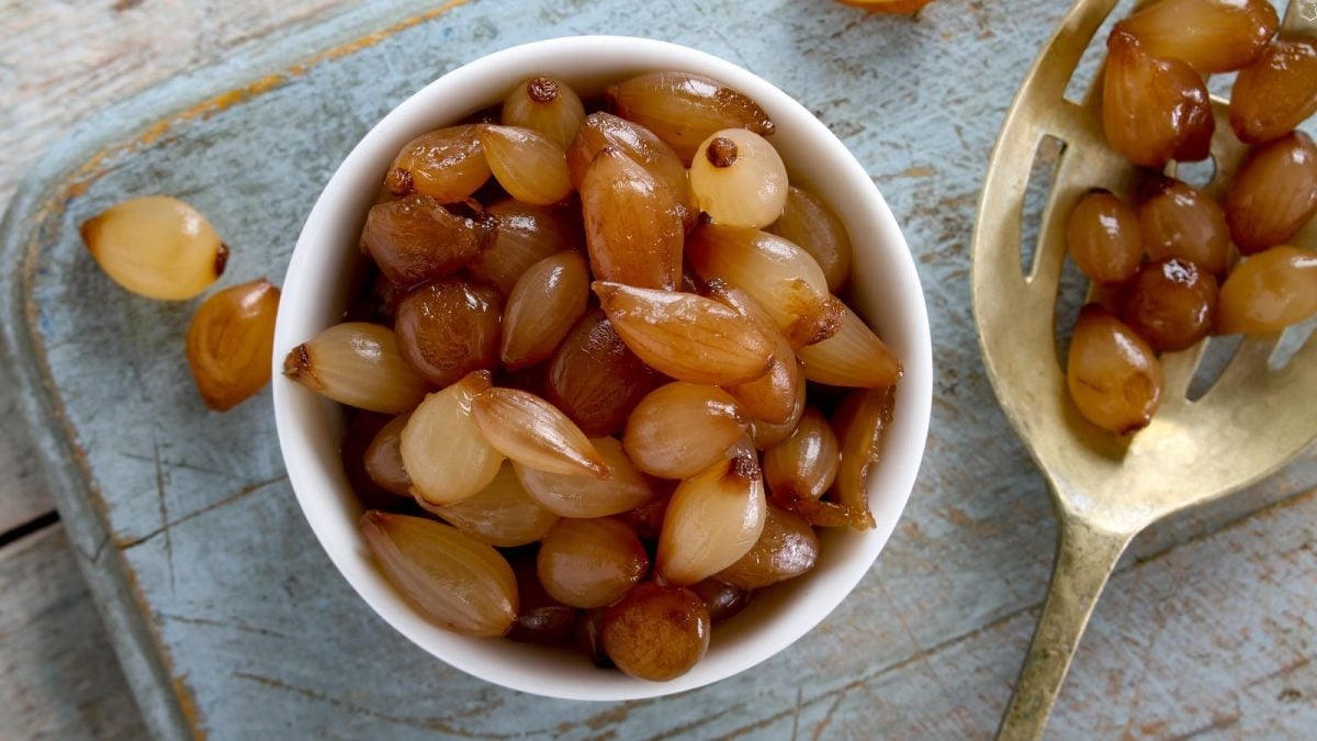 Eine Schüssel mit Balsamico-Zwiebeln auf einem hellblauen Tuch.