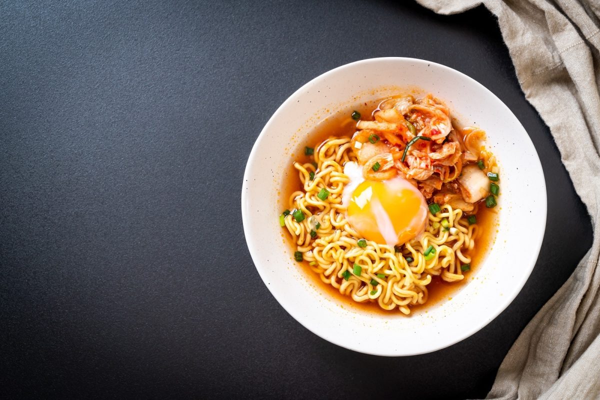 Ein Tisch mit Instant Ramen neben einem grauen Tuch.