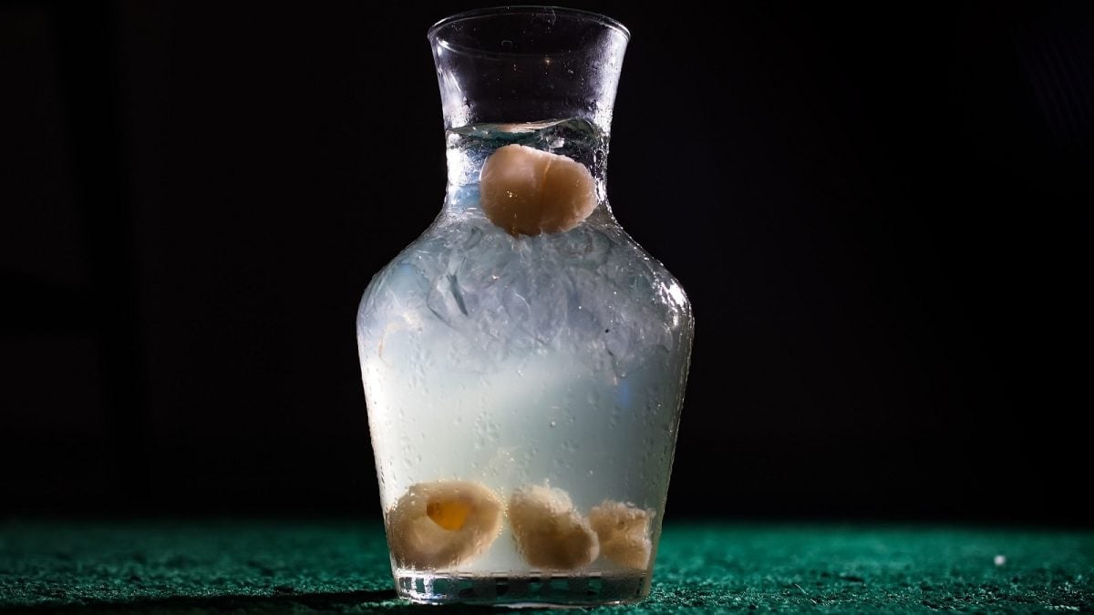 Eine Flasche mit Litschi-Sirup auf einem dunklen Hintergrund.