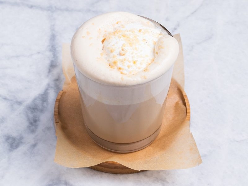 Ein Glas mit White Chocolate Latte auf einer Untertasse