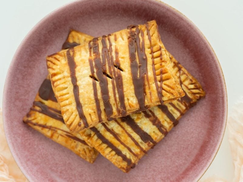 Vegane Pop Tarts mit Schokolade auf einem rosa Teller vor hellem Hintergrund.