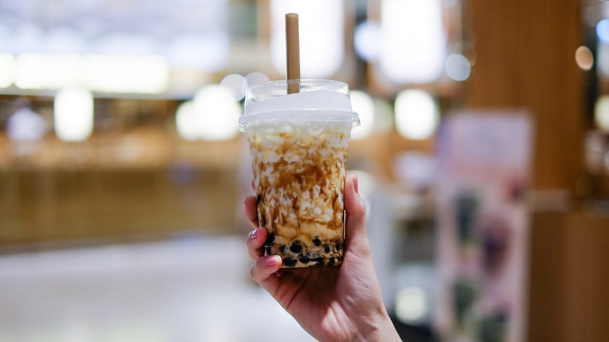 Hand einer Frau, die Bubble Tea festhält.