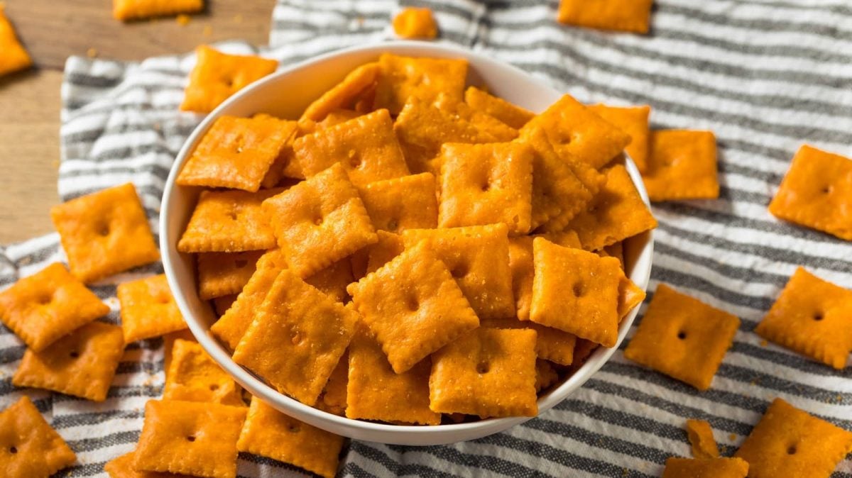 Eine Schüssel mit Cheddar Cracker auf einem Geschirrtuch.
