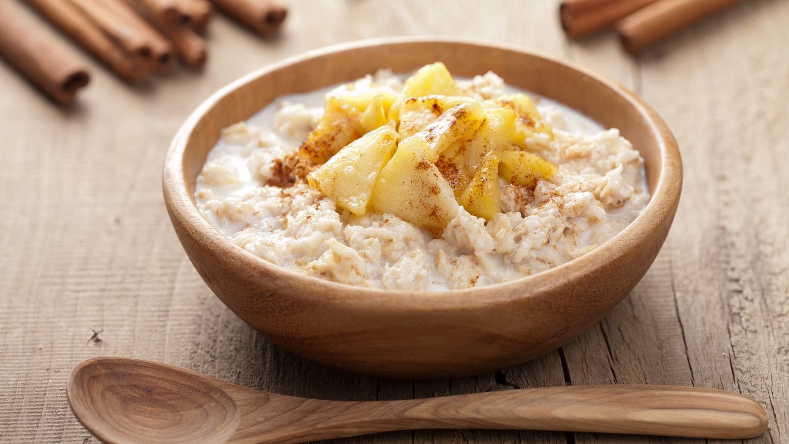 Eine braune Schüssel mit Chai-Porridge auf einem Holztisch.