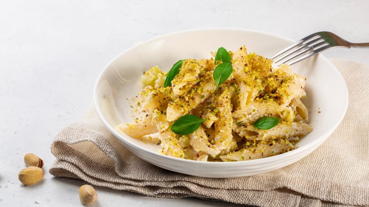 Ein weißer Pastateller mit Pasta mit Pistaziencreme.