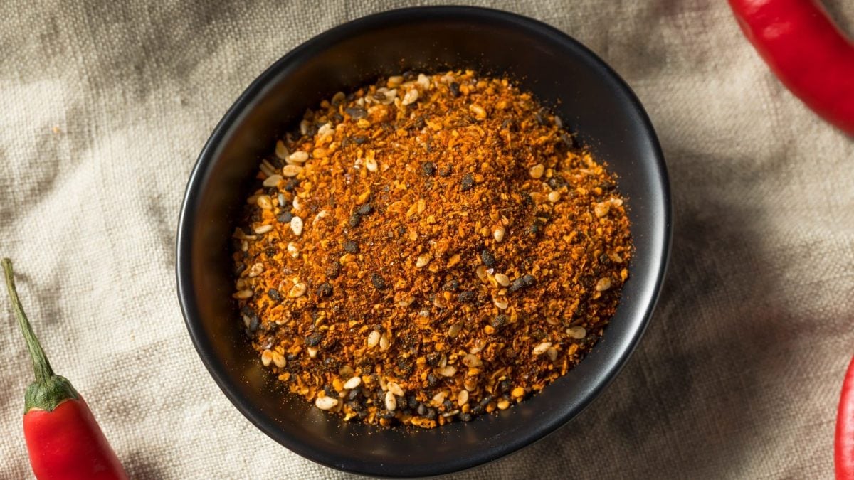 Eine schwarze kleine Schale mit Shichimi Togarashi auf einem Tuch.