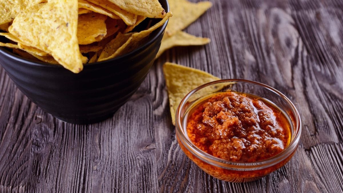 Salsa Lizano mit Nachos auf Holztisch. Draufsicht.