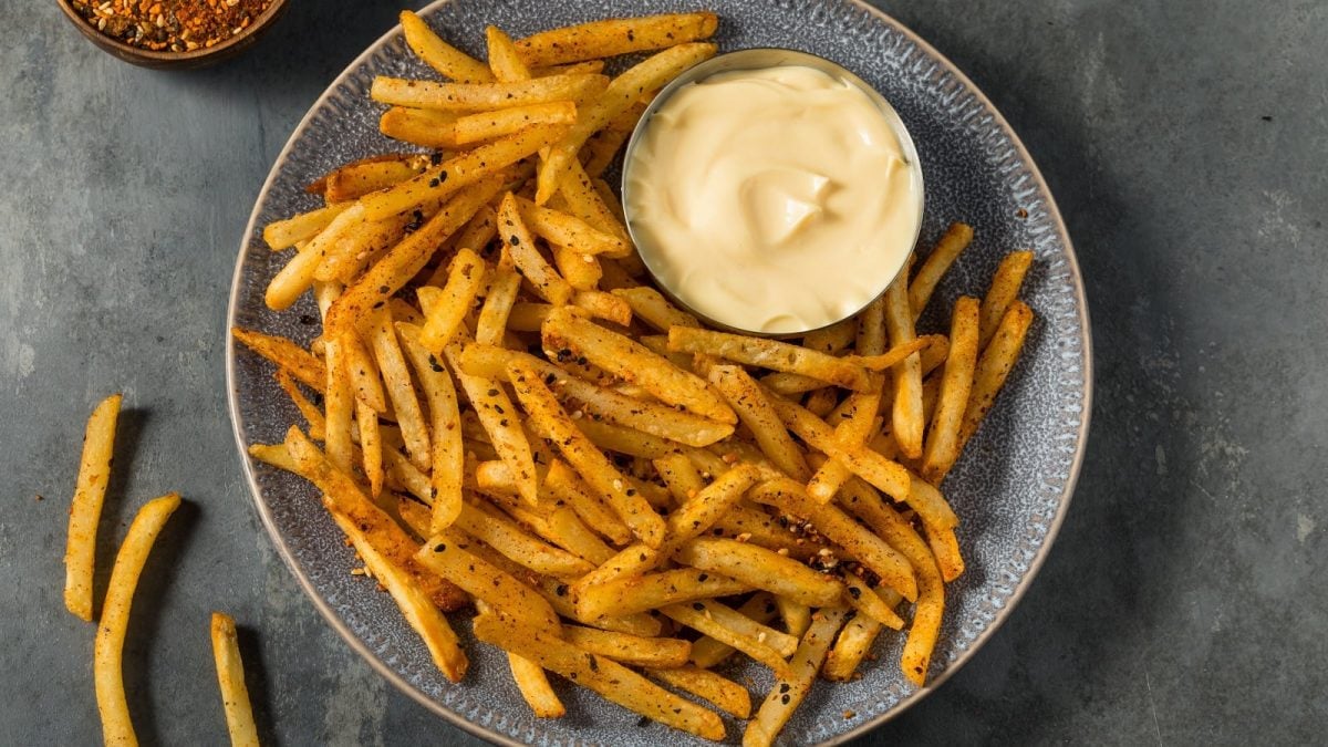 Ein grauer Teller mit Shichimi Togarashi Fries auf einem grauen Tisch.