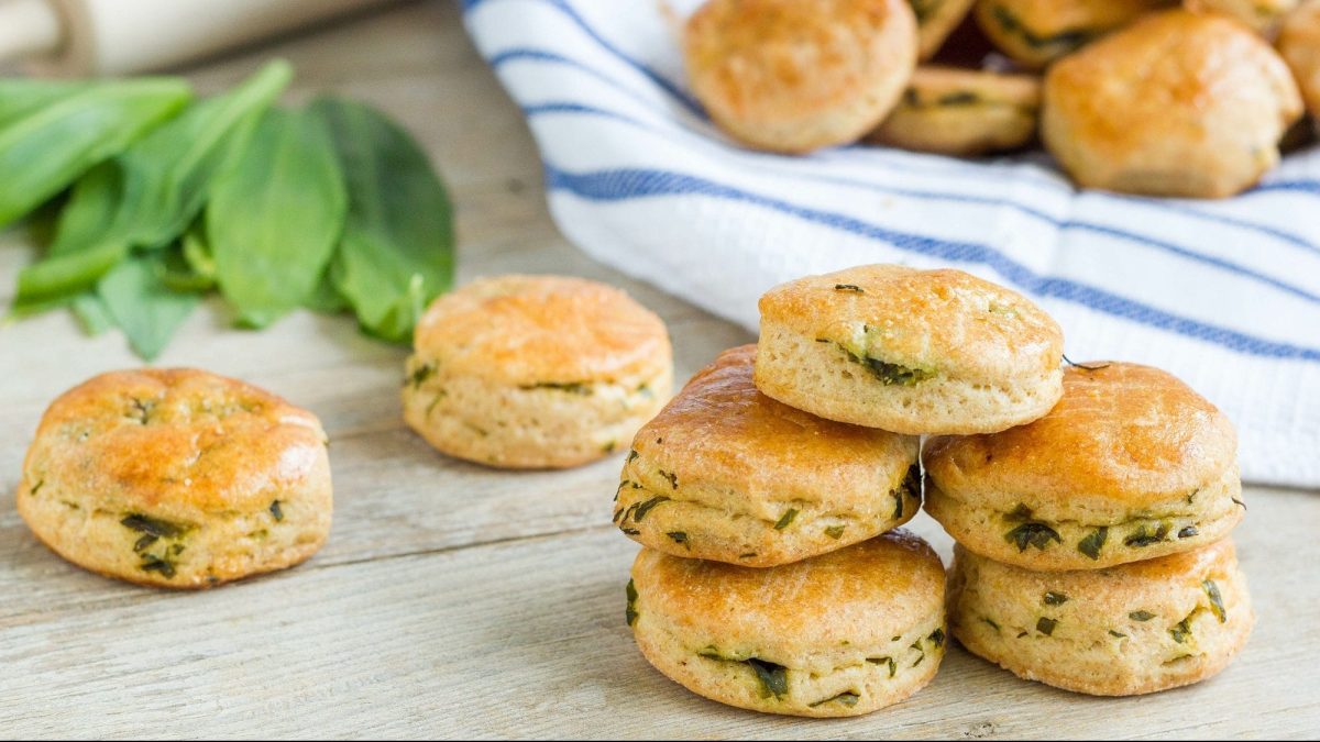 Ein Stapel Bärlauch-Scones, im Hintergrund unscharf weitere Scones und frischer Bärlauch.