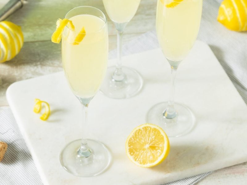 Mehrere Gläser mit dem Dry Limoni auf einem hellen Untergrund mit Zitrone.