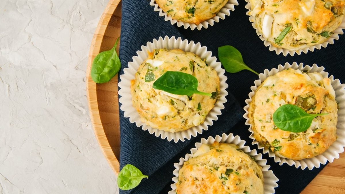 Ein rundes Holztablett mit Bärlauch-Muffins mit Feta.