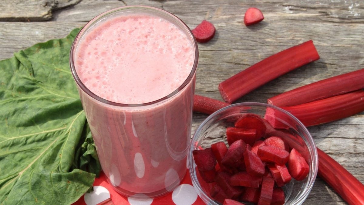 Ein Glas mit Rhabarber-Smoothie auf einem rot-weiß gepunkteten Tuch.
