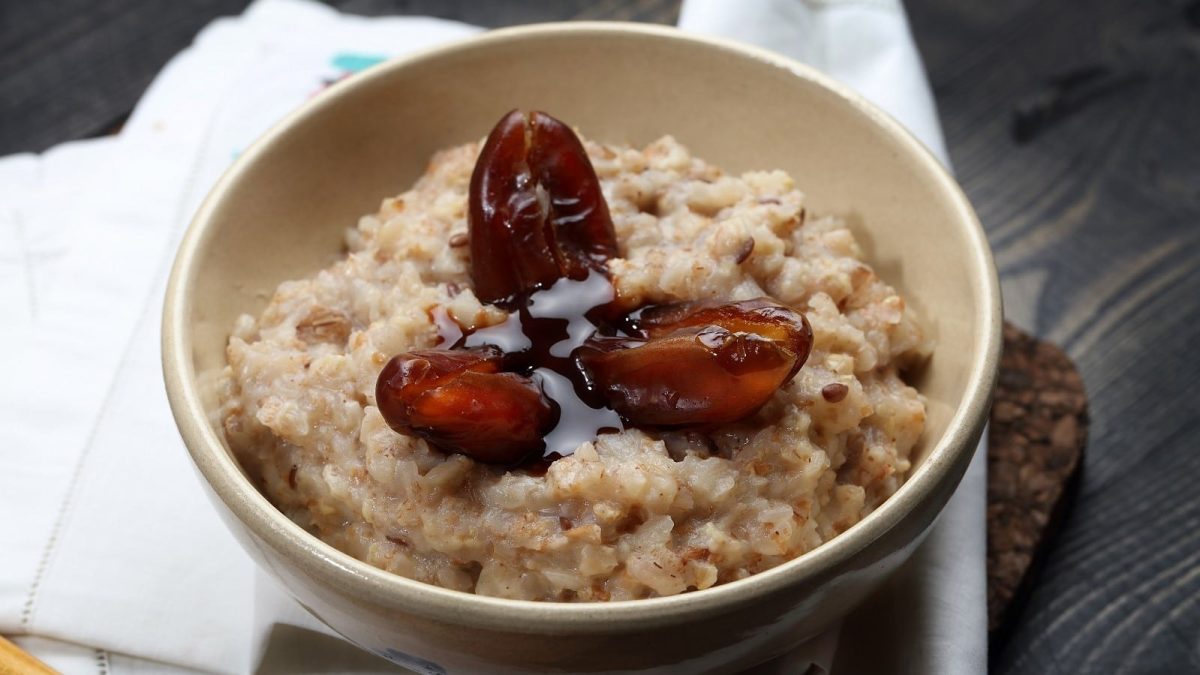 Eine Schüssel mit Tahini-Dattel-Porridge auf einem weißen Tuch.