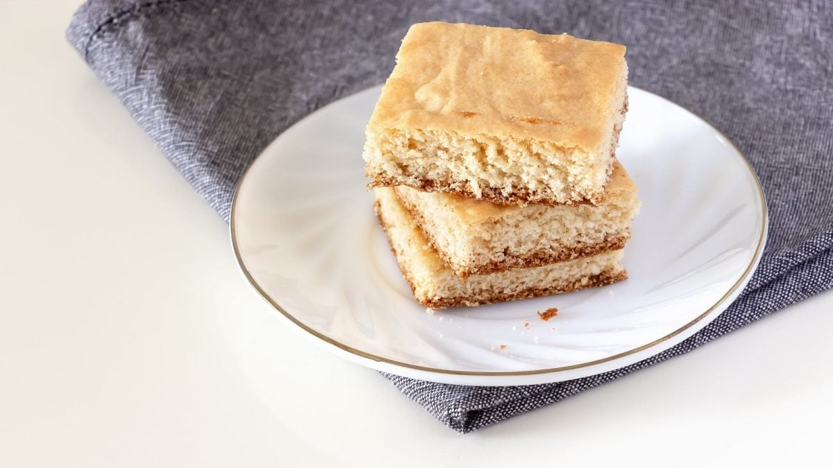 Ein weißer Teller mit einem Stapel Kokos-Blondies darauf.