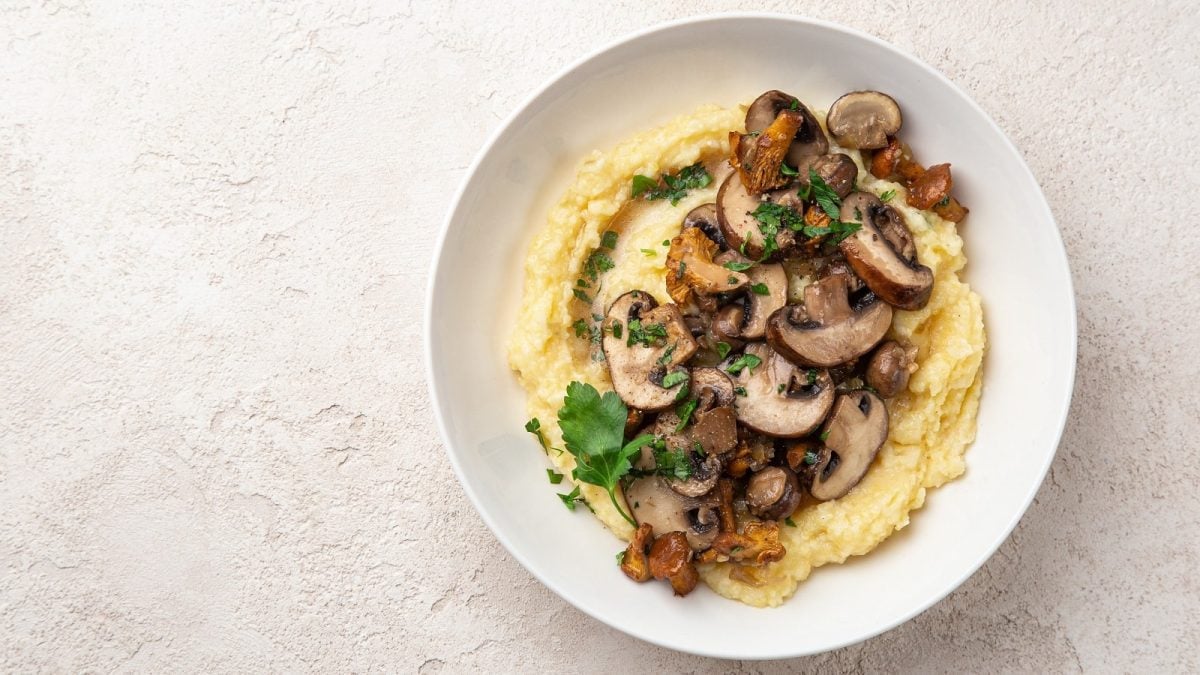 Ein weißer Teller mit Miso Polenta auf einem hellen Tisch.