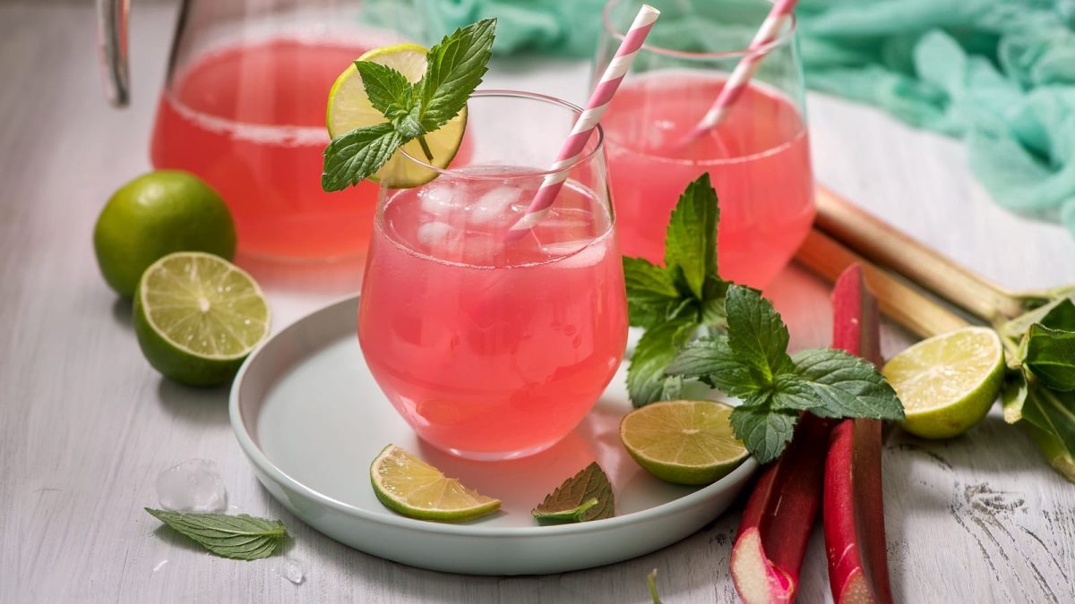 Ein flacher Teller mit zwei Gläsern Erdbeer-Rhabarber-Limonade.