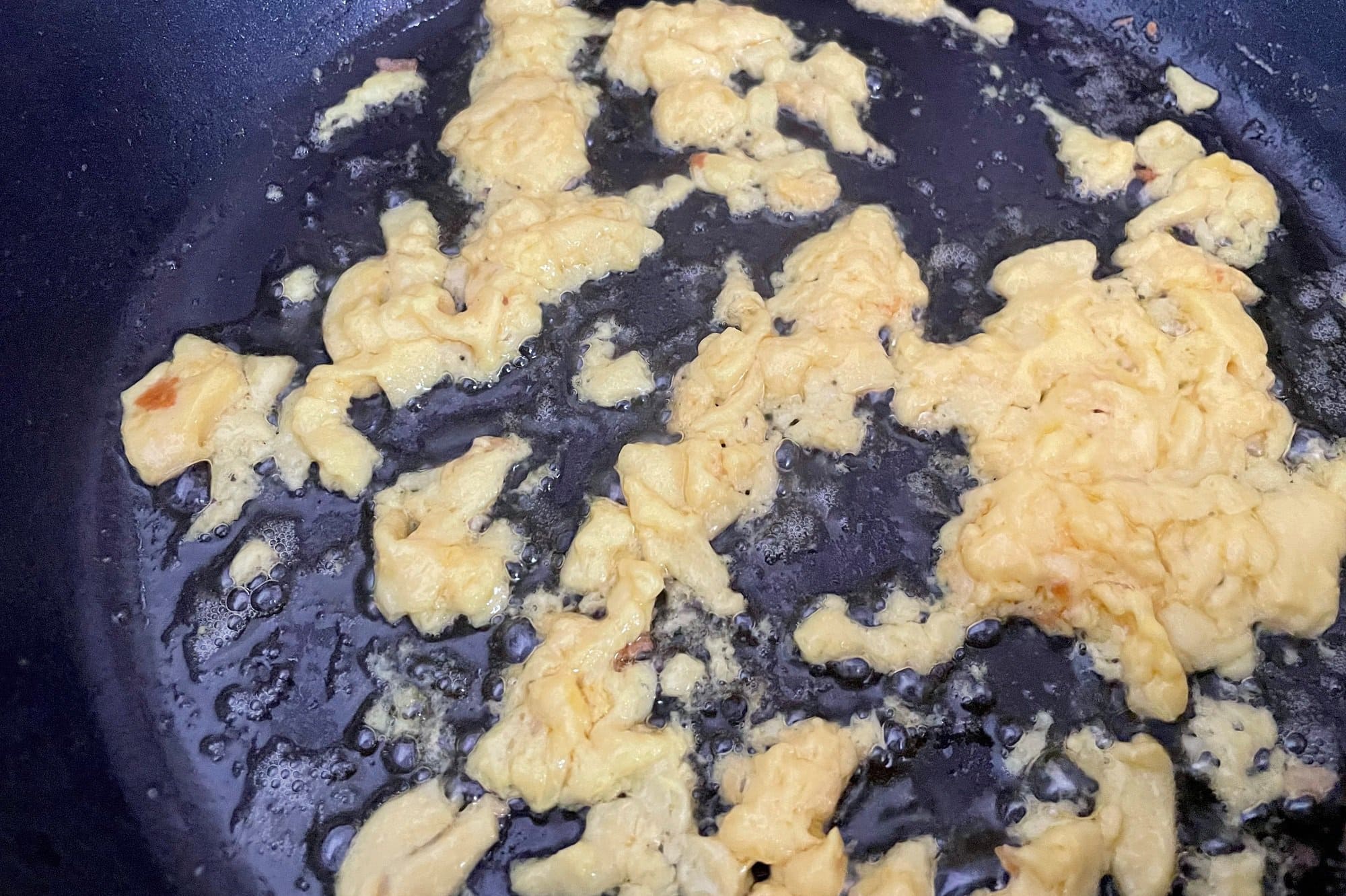 Veganes Ei brät in einer Pfanne.