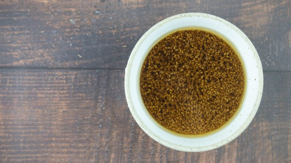 Eine weiße Schüssel mit Wasabi-Dressing auf einem Holztisch.