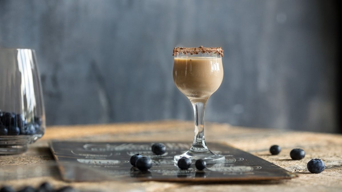 Ein Glas mit Bounty-Likör auf einer grauen Platte.