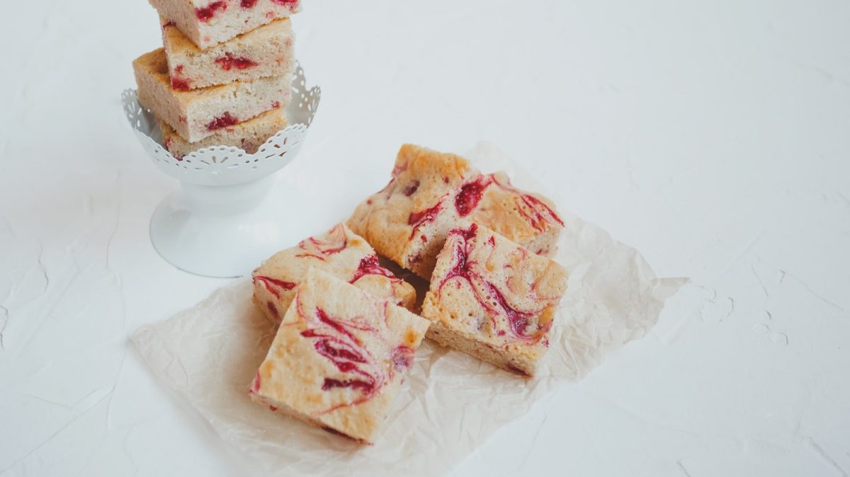 Ein paar Stücke Rhabarber Blondies auf weißem Hintergrund.