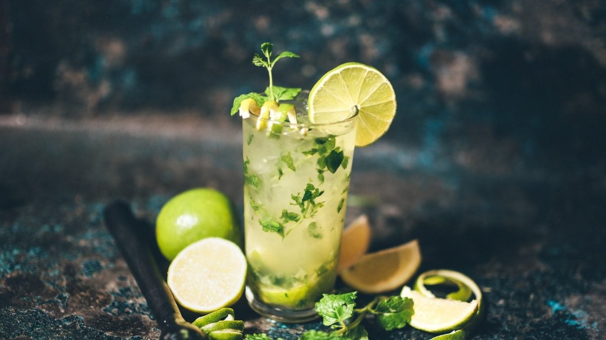 Ein Glas Frozen Mojito garniert mit Limetten und Minze.
