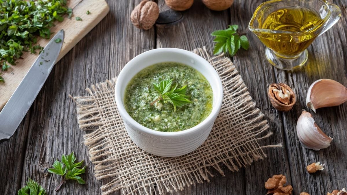 Eine kleine Schüssel mit Giersch-Pesto auf einem Stück Stoff.