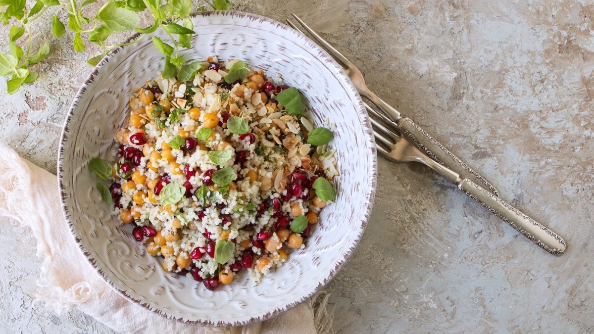 Ein Teller mit Granatapfel-Couscous mit Kichererbsen.
