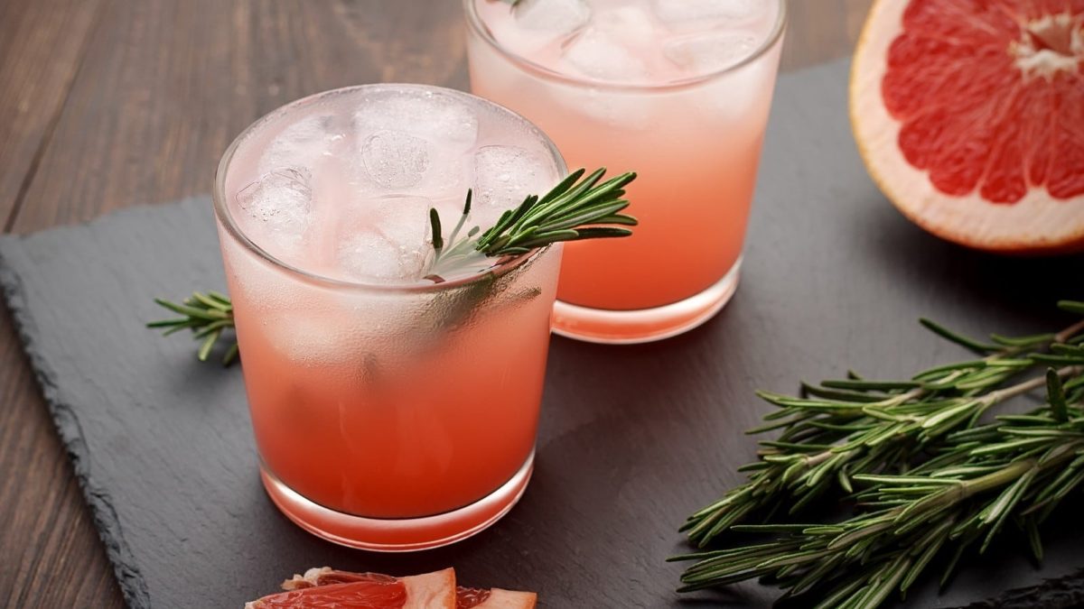 Zwei Gläser mit Grapefruit-Eistee mit Rosmarin.