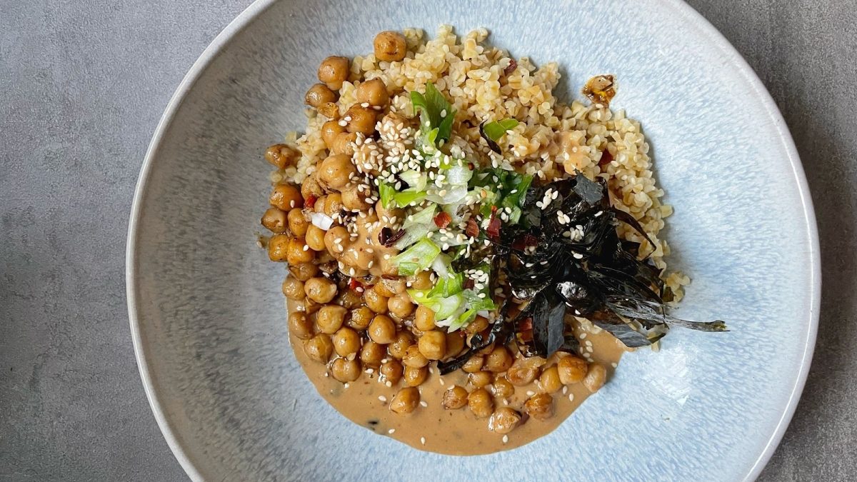 Eine Kichererbsen-Bowl mit Chili-Tahini auf einem grauen Tisch.