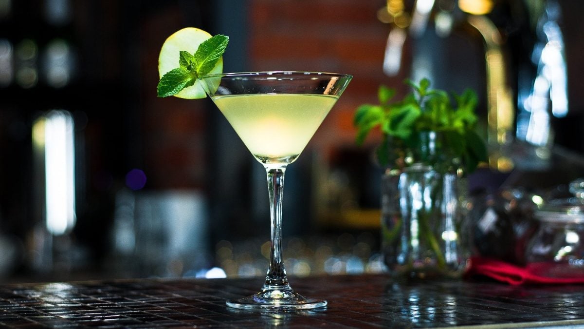 Ein Glas mit Matcha-Limetten-Daiquiri vor einem dunklen Hintergrund.