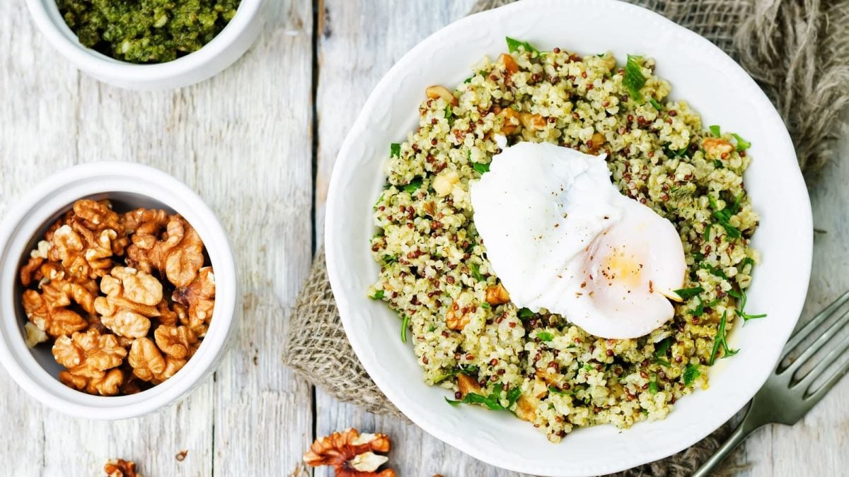 Ein weißer Teller mit Quinoa-Salat mit Bärlauch-Pesto.