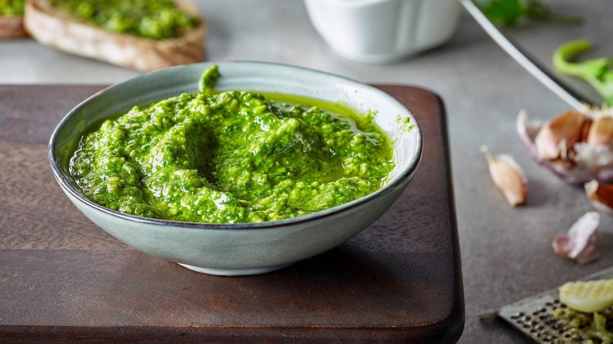 Eine Schüssel mit Shiso Pesto auf einem Holzbrett.