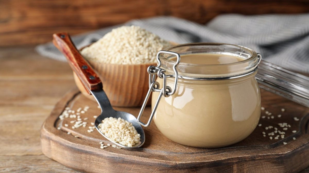 Ein Weckglas mit Tahini auf einem Holzbrett.