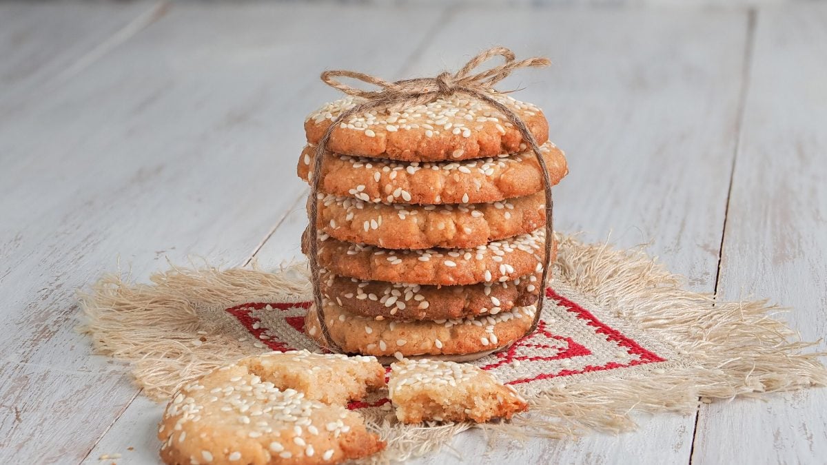 Ein Stapel Tahini-Kekse mit einer Schleife fixiert, davor ein zerbrochener Keks.