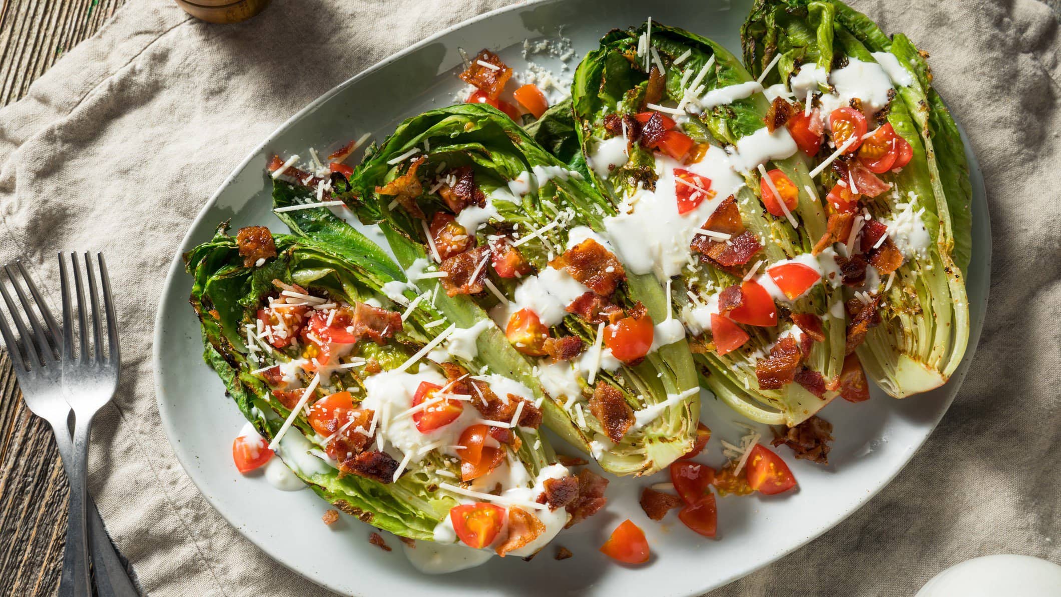 Gegrillter Römersalat mit Tomate, Bacon und Gorgonzoladressing.