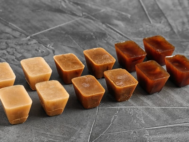 Eine Reihe an Kaffee-Eiswürfeln auf einem grauen Tisch.
