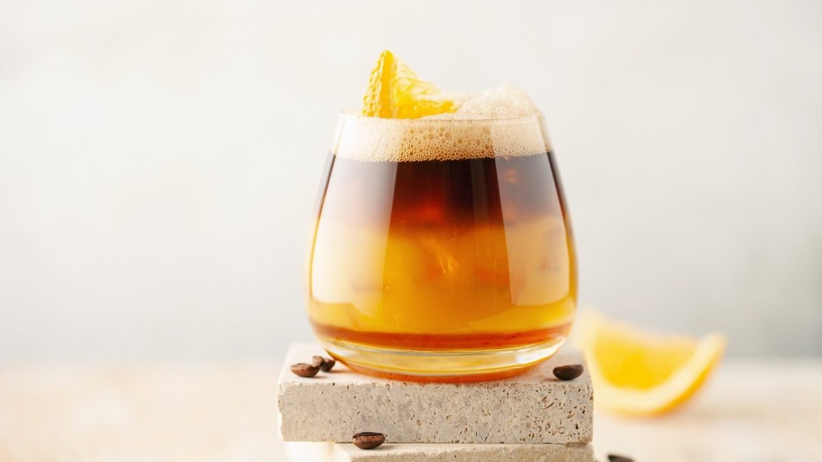 Ein Glas mit Kaffeelimonade auf einem Stein.