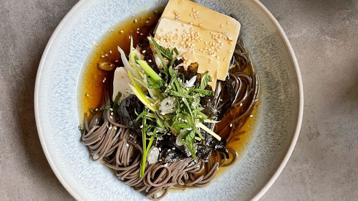 Ein Teller mit Memil Guksu auf einem grauen Hintergrund.