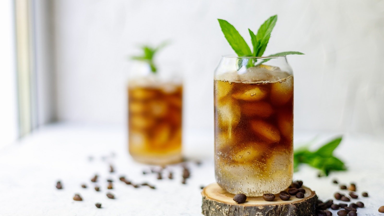 Zwei Gläser mit Mint Cold Brew auf weißem Hintergrund.
