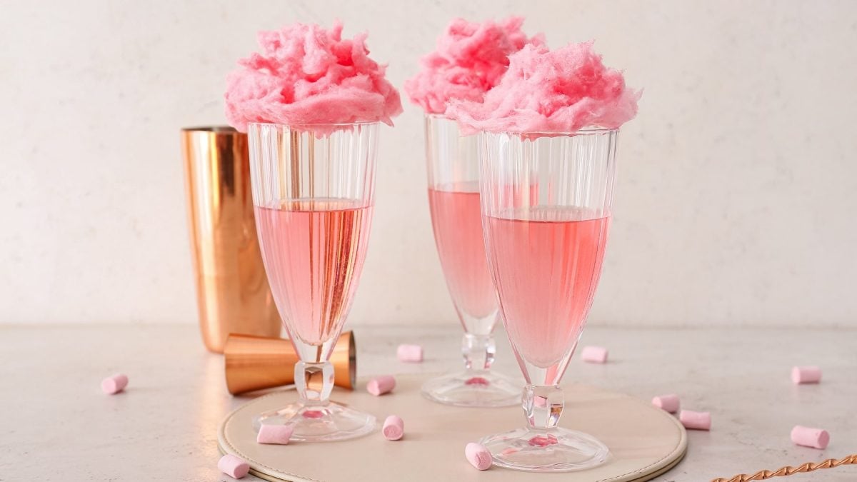 Drei Gläser Rhabarber-Spritz mit Zuckerwatte garniert.