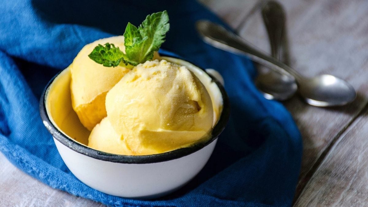 Eine weiße Schüssel mit Mango-Eis auf einem blauen Tuch.