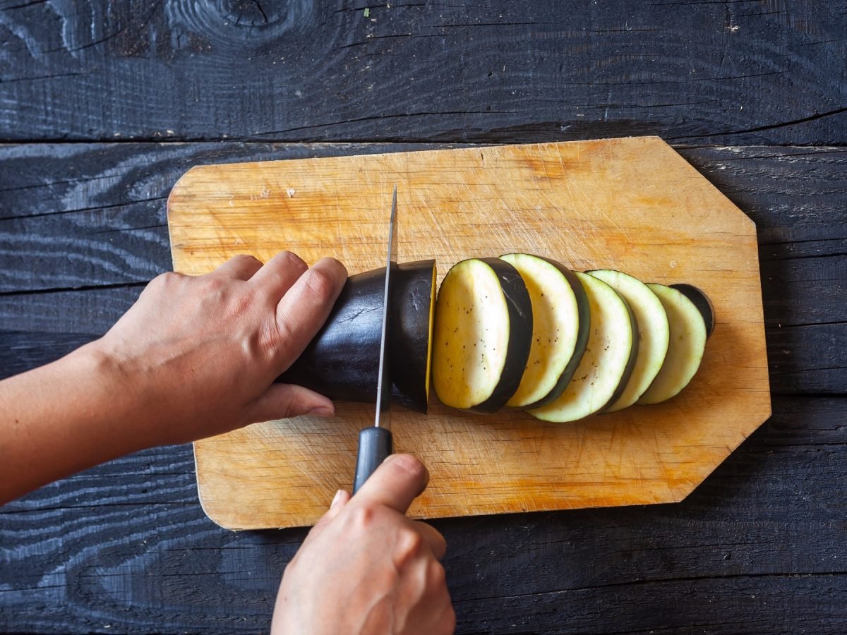 Schneiden einer Aubergine in Ringe zum Einfrieren.