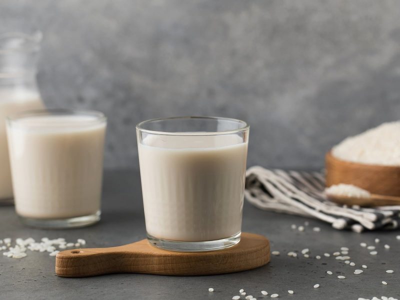 Zwei Gläser mit Reismilch auf einem Holztablett.