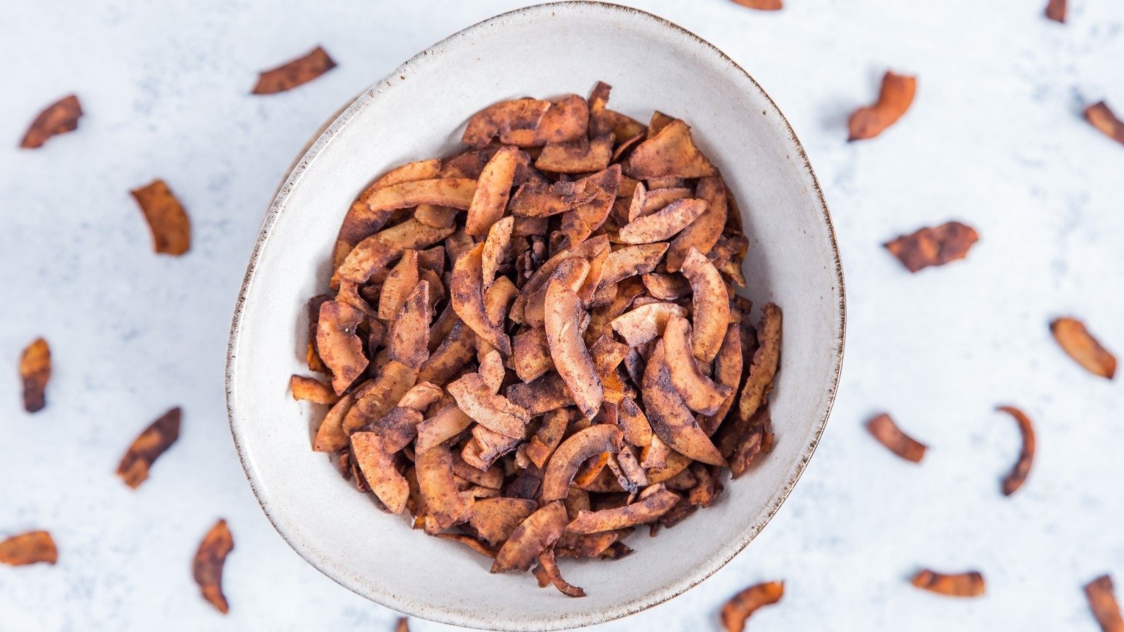 Eine Schüssel mit veganem Kokos-Bacon auf einem hellen Tisch.