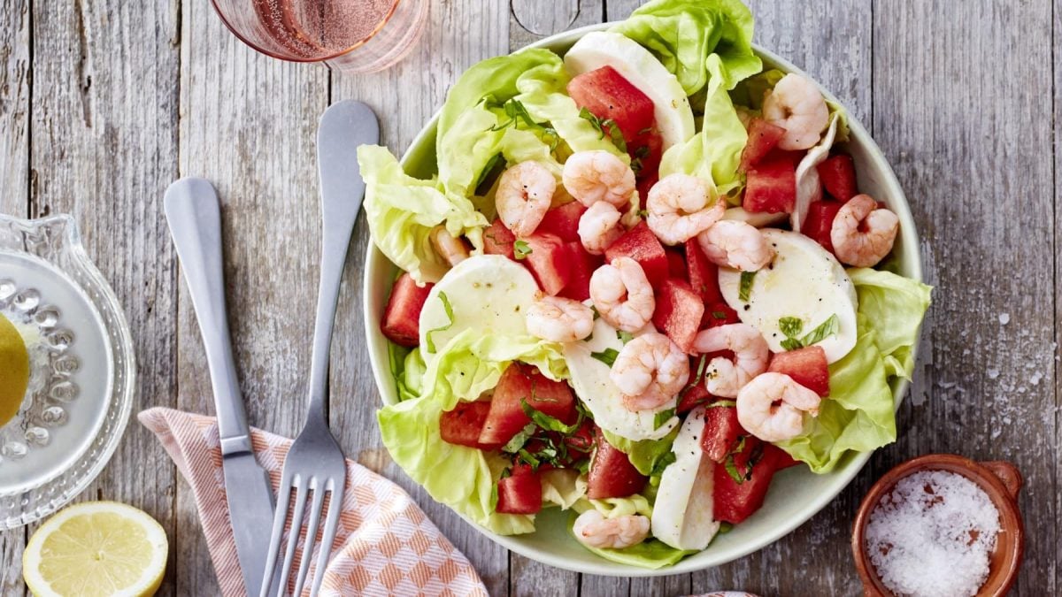 In einer Schüssel ist ein Wassermelonen-Salat mit Mozzarella angerichtet. Er ist mit Garnelen verfeinert.