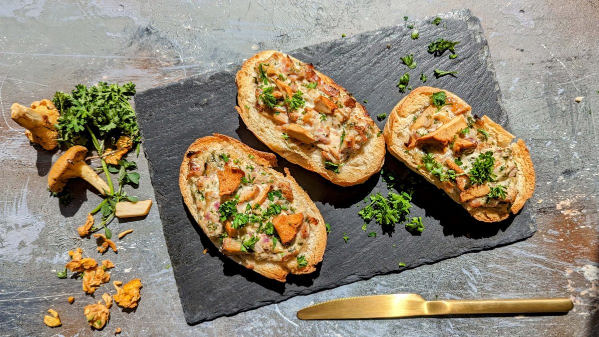 Drei Brötchenhälften mit der Flammkuchenfüllung und Pfifferlingen.