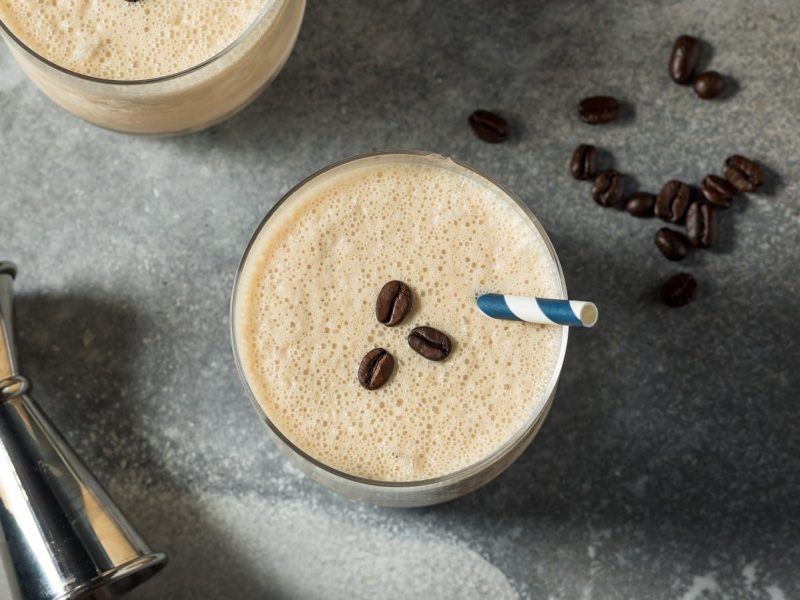 Ein Glas Frozen White Russian auf einem grauen Tisch.