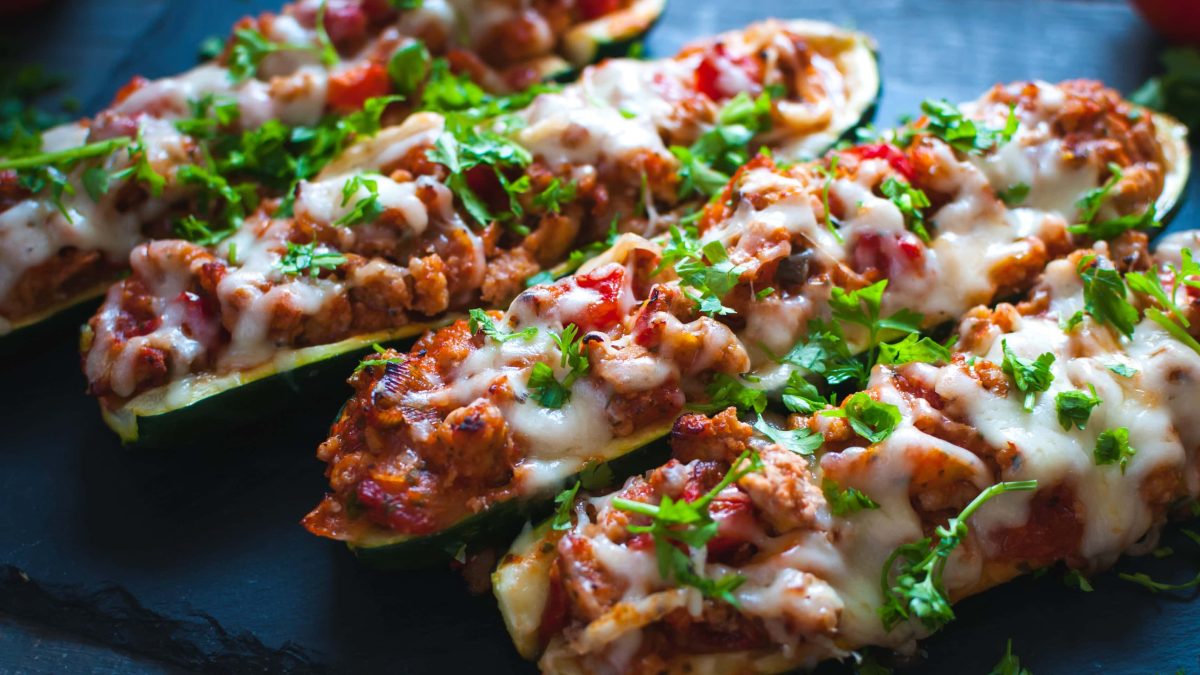 Gefüllte Zucchini mit Hackfleisch auf schwarzem Untergrund. Draufsicht.
