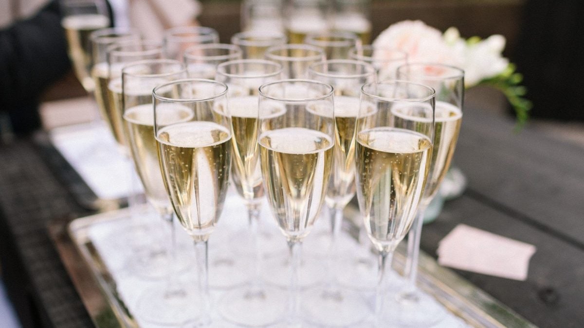 Frontal: Mehrere gefüllte Prosecco-Gläser stehen hinter einander.
